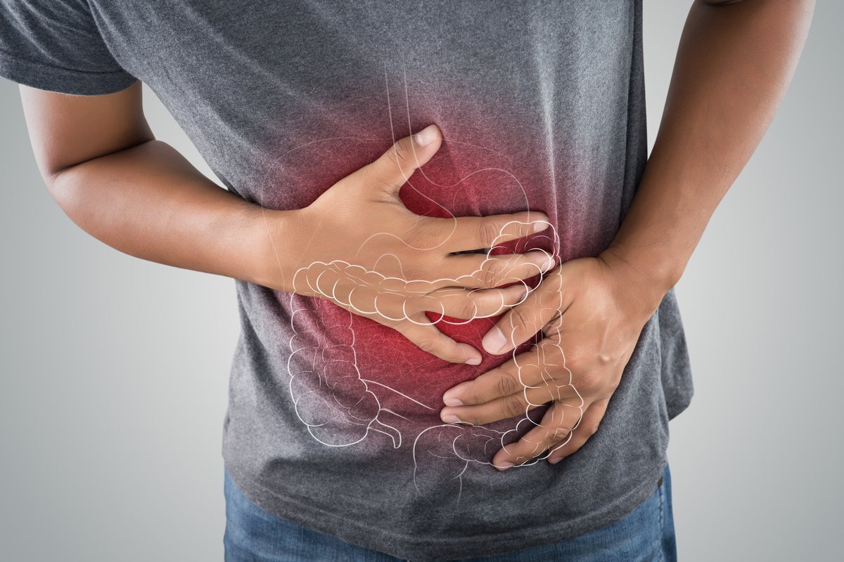 Person holding their abdomen, with the large bowel illustrated