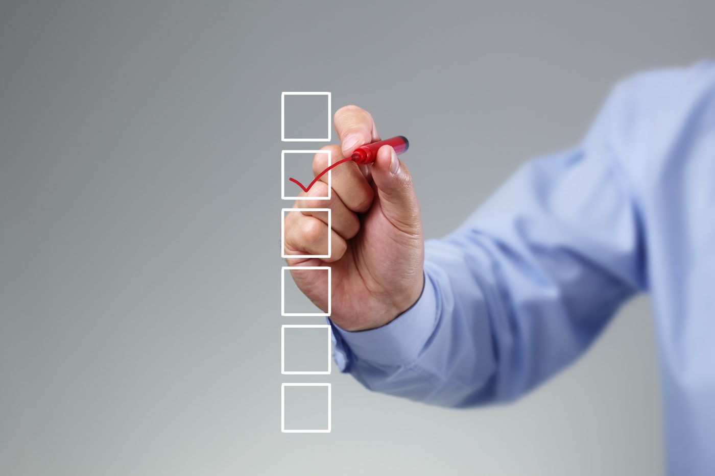 A hand ticking boxes on a checklist