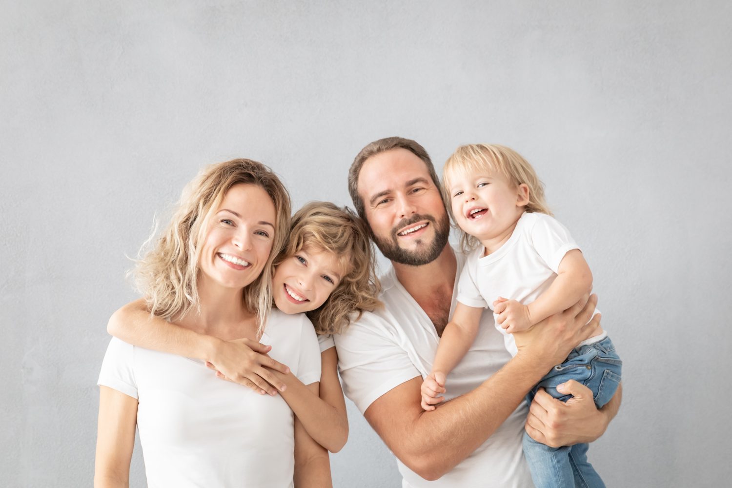 A family of four smiling together