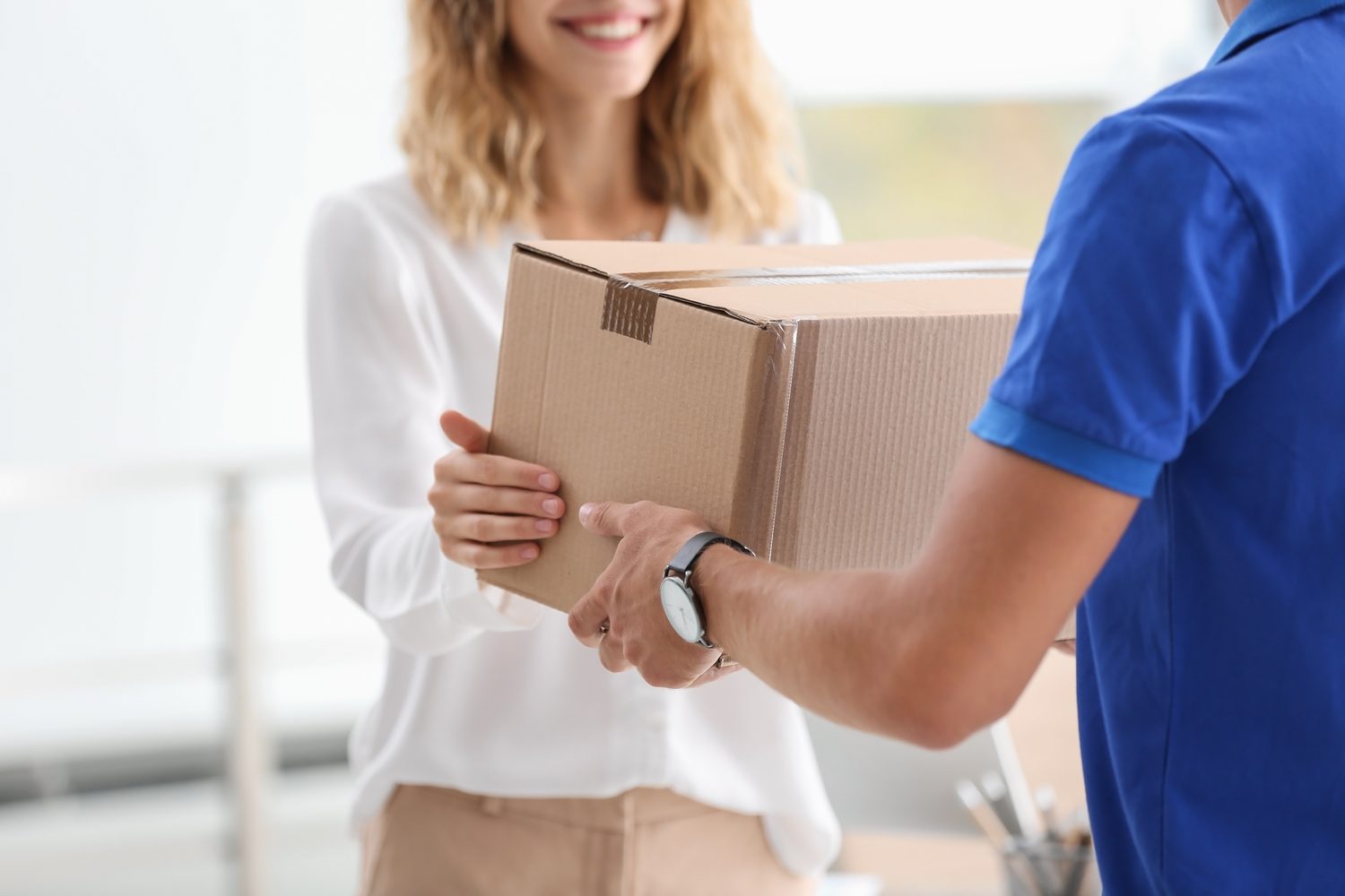 A courier handing over a plain parcel