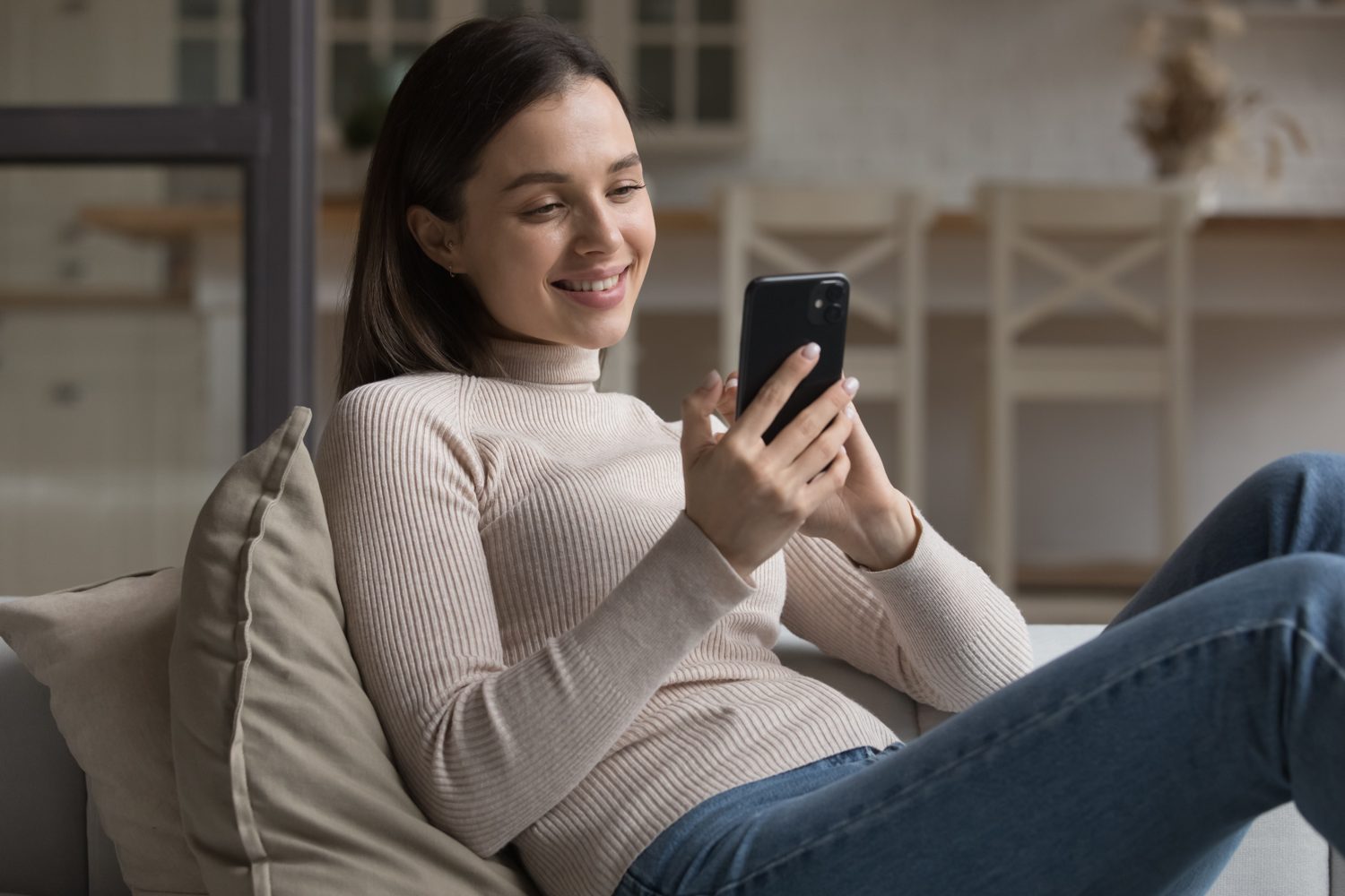 Woman at home reading a message on her phone